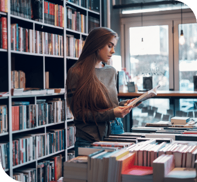 A woman reading a book in a bookstore.