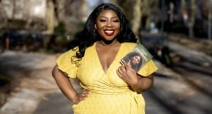 Woman in yellow dress holding a book