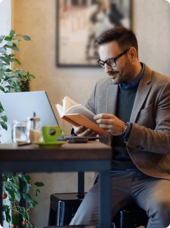 Young man reading a book at the table