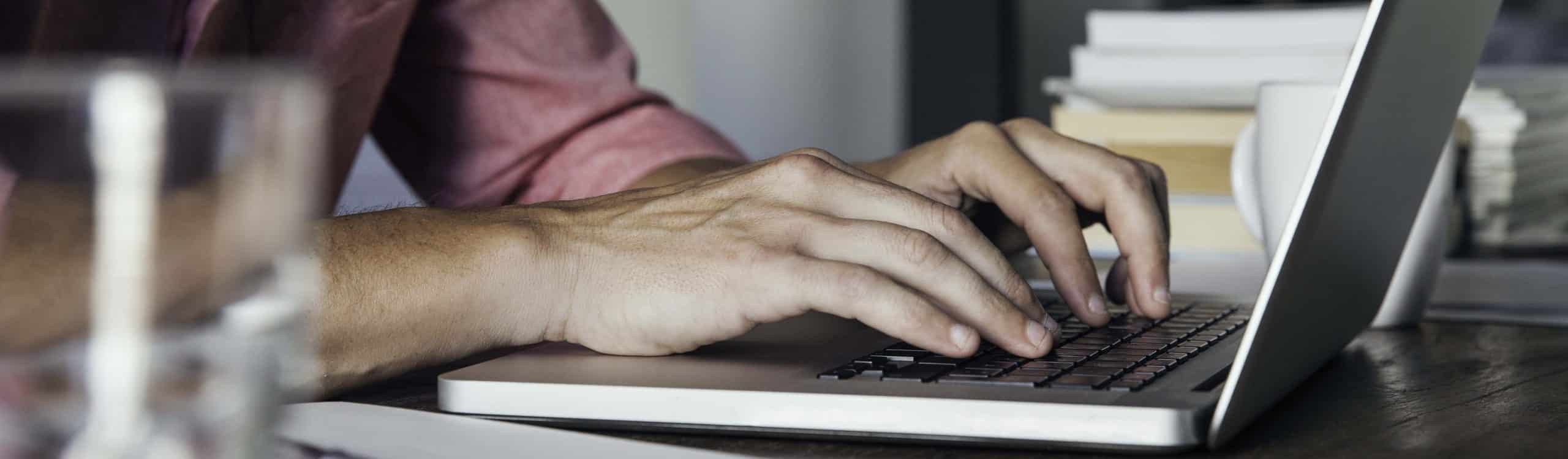 author typing on laptop