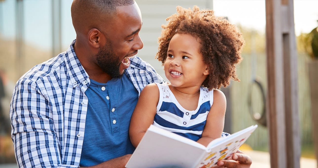 African American male reading a book to a child