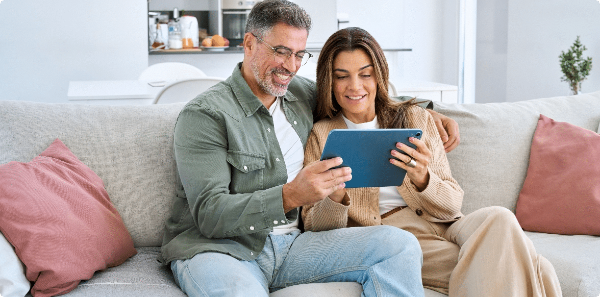 Ideal Reading Experience Across Formats, Couple looking at a device on a couch