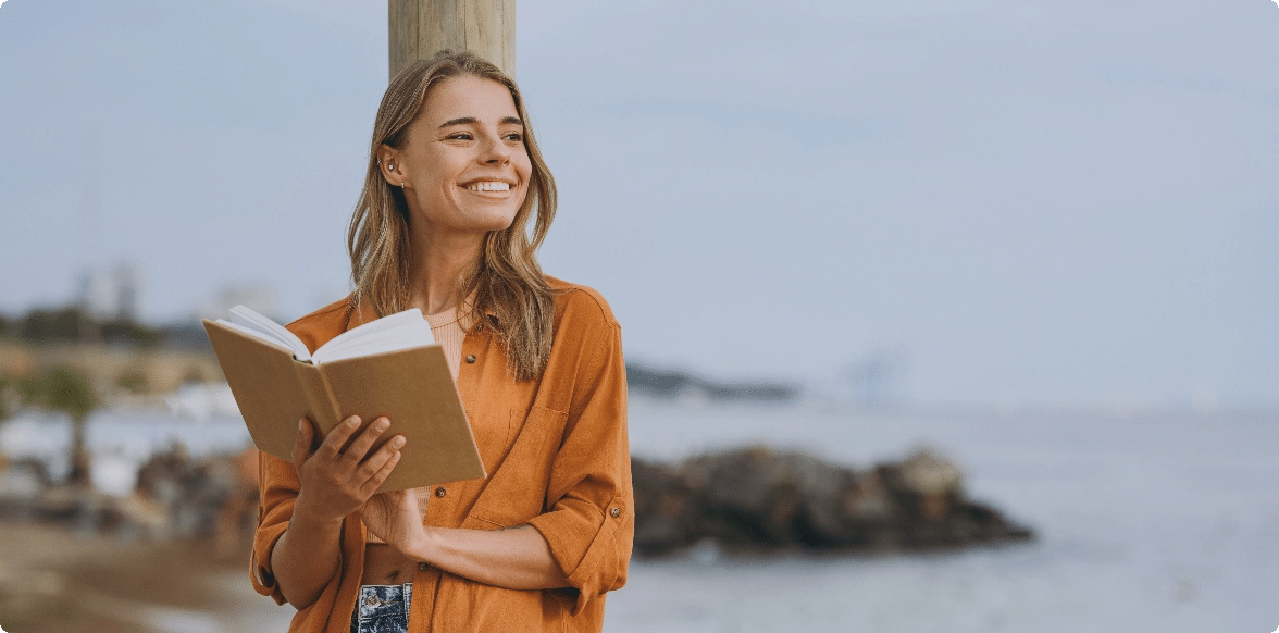 You Know How to Write a Book — Now Do It, Woman with a book by a wooden post